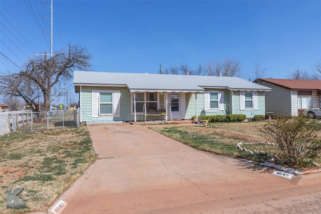 ranch-style home featuring a gate, concrete driveway, a front lawn, and fence