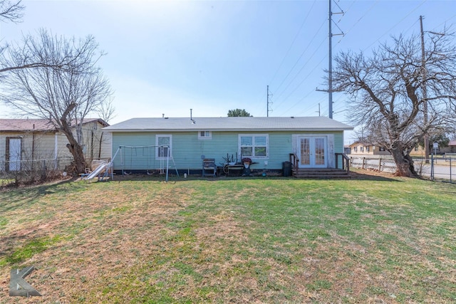 back of property featuring french doors, a yard, a fenced backyard, and entry steps