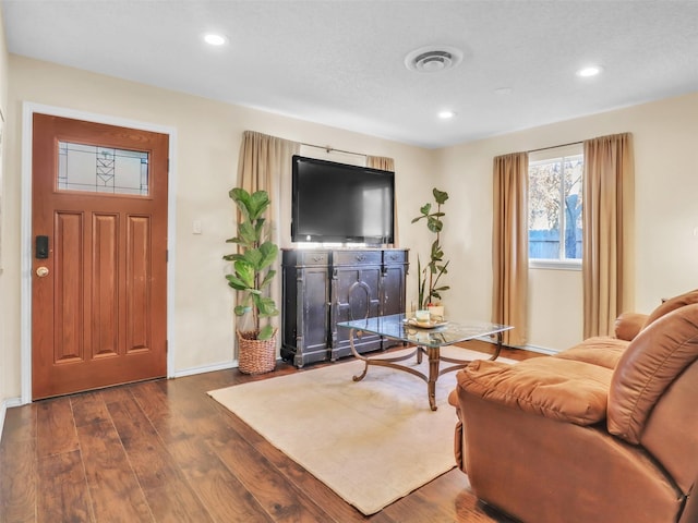 living area featuring dark wood finished floors, visible vents, recessed lighting, and baseboards