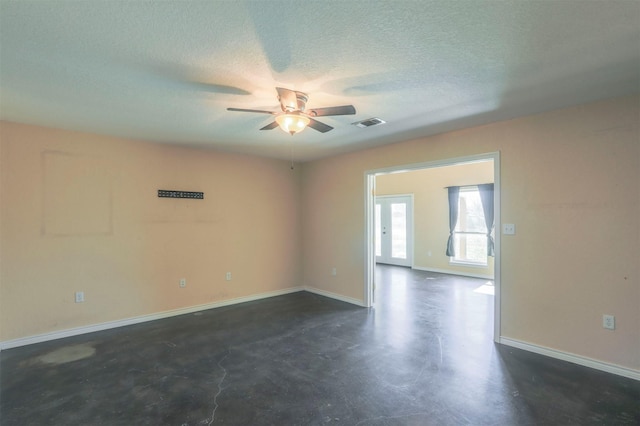 empty room with visible vents, baseboards, finished concrete floors, a textured ceiling, and a ceiling fan