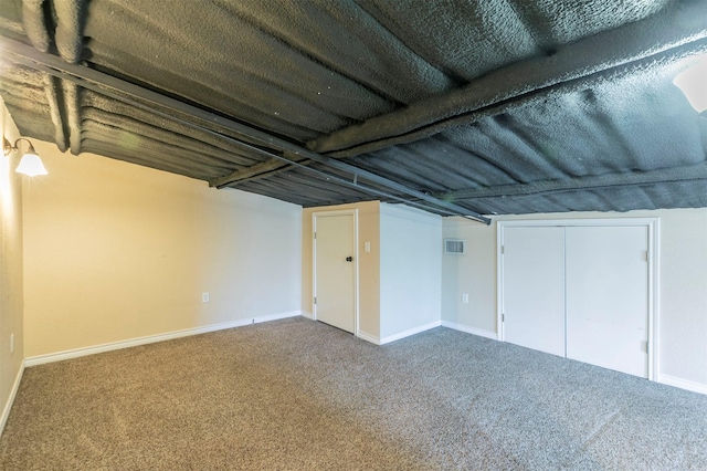 finished below grade area featuring carpet flooring, baseboards, and visible vents