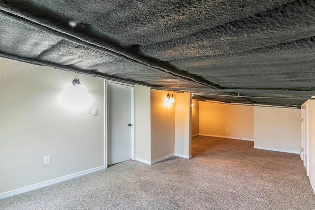 finished basement featuring carpet flooring, a textured ceiling, and baseboards