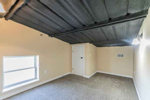 interior space with visible vents, baseboards, and vaulted ceiling