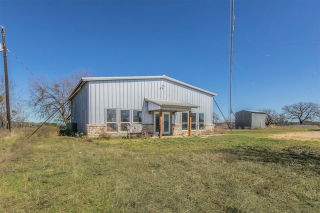 rear view of property with stone siding and board and batten siding