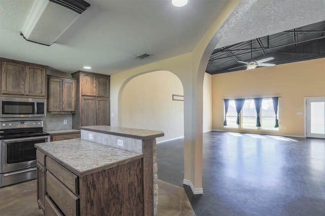 kitchen with finished concrete flooring, visible vents, a kitchen island, stainless steel appliances, and open floor plan