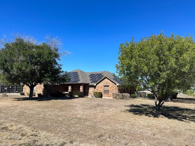 view of front of property with solar panels and brick siding