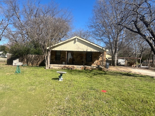 view of front of home with stone siding, a front yard, and fence