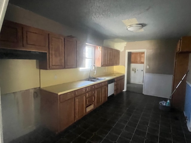 kitchen with a sink, a textured ceiling, white dishwasher, and light countertops