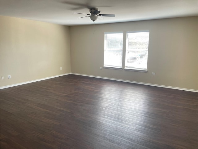 empty room with dark wood-style floors, ceiling fan, and baseboards