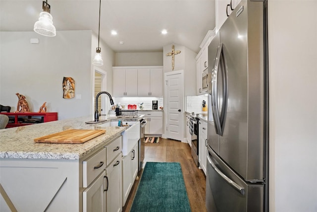 kitchen with decorative light fixtures, backsplash, dark wood-style floors, appliances with stainless steel finishes, and white cabinets