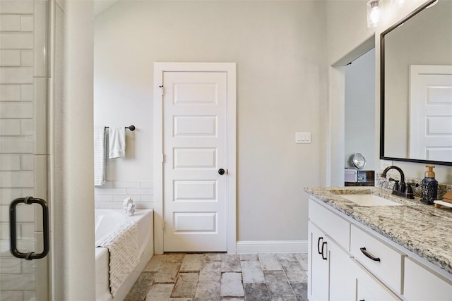 bathroom with vanity, a garden tub, baseboards, and a stall shower