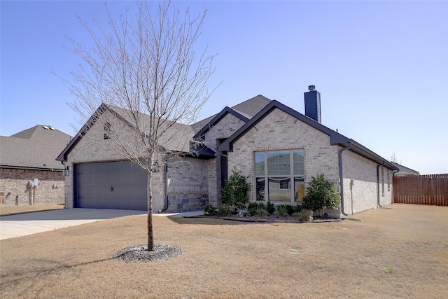 view of front of house featuring brick siding, an attached garage, fence, a chimney, and driveway