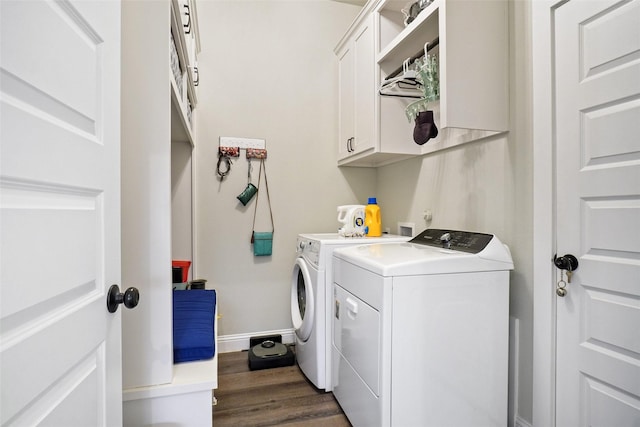 laundry room with baseboards, cabinet space, dark wood-type flooring, and washing machine and clothes dryer