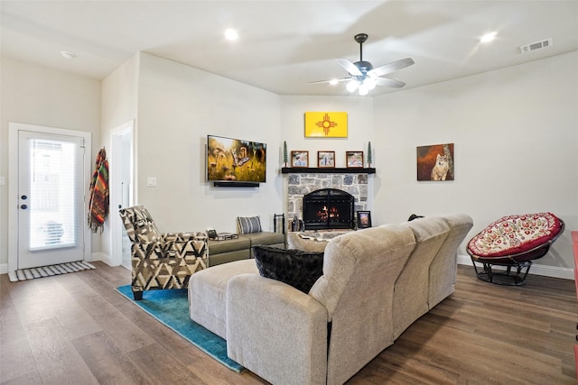 living area with visible vents, baseboards, wood finished floors, and a fireplace