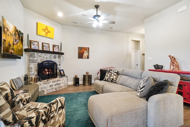 living area with visible vents, a fireplace, a ceiling fan, and wood finished floors