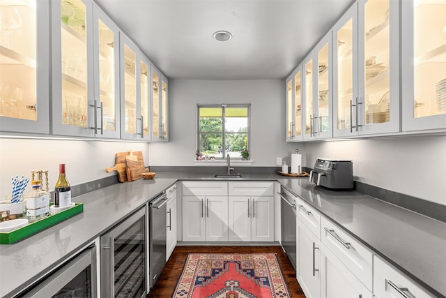 kitchen with glass insert cabinets, wine cooler, stainless steel dishwasher, white cabinetry, and a sink