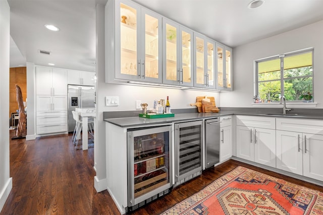 kitchen featuring wine cooler, visible vents, stainless steel refrigerator with ice dispenser, and a sink