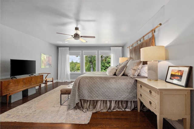 bedroom featuring dark wood finished floors, a ceiling fan, and baseboards