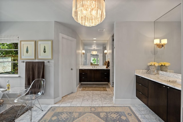 bathroom with marble finish floor, baseboards, vanity, and a healthy amount of sunlight