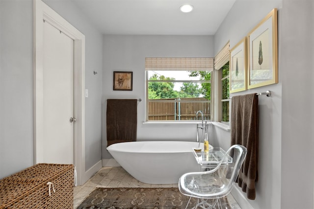 full bath featuring a soaking tub, recessed lighting, and baseboards