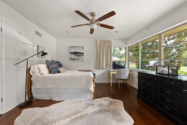 bedroom featuring visible vents, a ceiling fan, baseboards, and wood finished floors