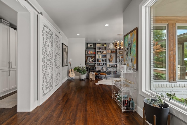 hallway with a notable chandelier, wood finished floors, recessed lighting, and baseboards