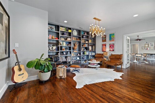 living area featuring ceiling fan with notable chandelier, recessed lighting, wood finished floors, and baseboards