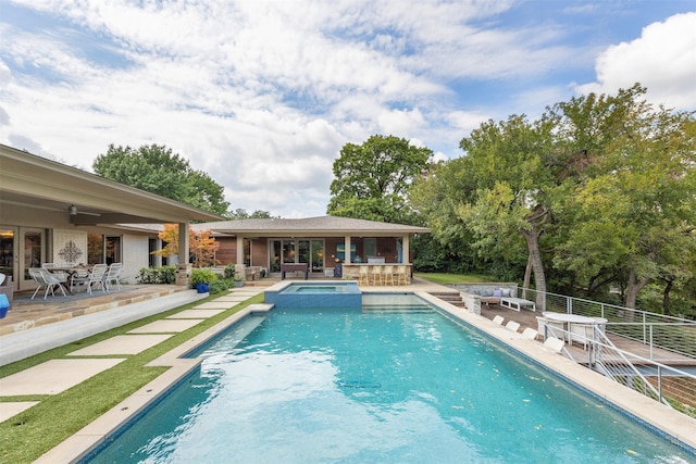 view of pool featuring a patio, a pool with connected hot tub, a ceiling fan, and french doors