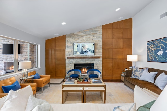 living area featuring recessed lighting, lofted ceiling, and a stone fireplace