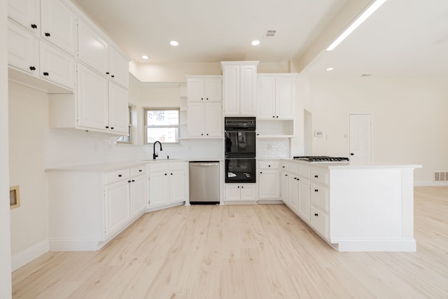 kitchen featuring decorative backsplash, a peninsula, stainless steel appliances, a sink, and open shelves