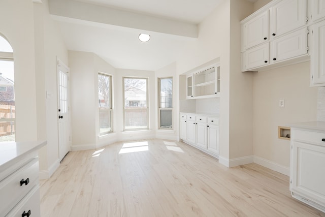 kitchen featuring white cabinetry, light countertops, baseboards, and light wood-type flooring