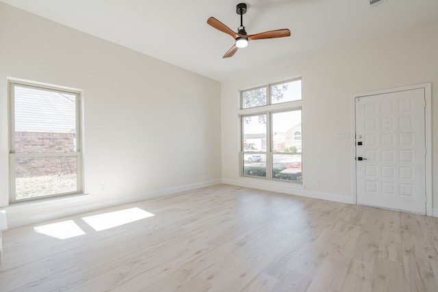 empty room featuring light wood-type flooring, baseboards, visible vents, and a ceiling fan