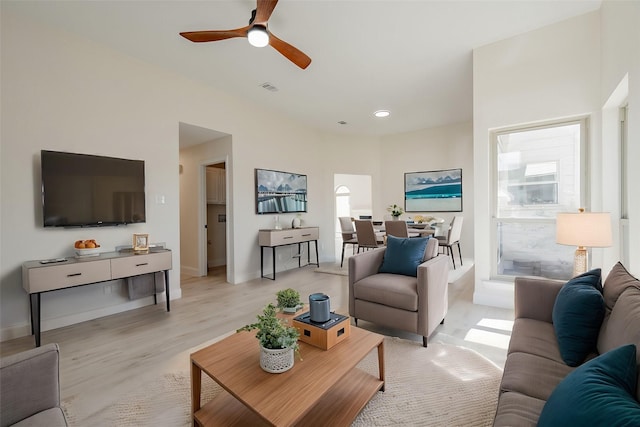 living room with baseboards, visible vents, light wood-style flooring, and ceiling fan