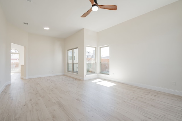 unfurnished room featuring baseboards, ceiling fan, visible vents, and light wood-style floors