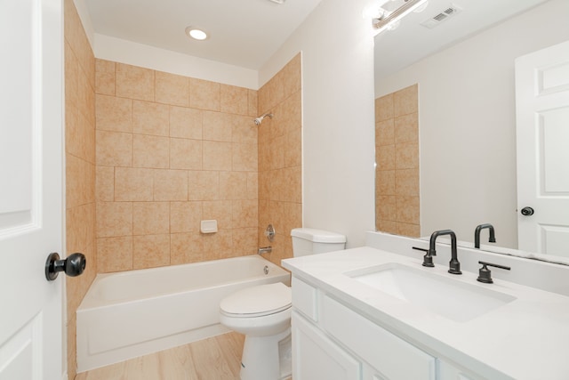 full bath with visible vents, shower / washtub combination, toilet, wood finished floors, and vanity