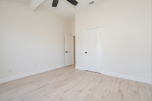 unfurnished room with visible vents, ceiling fan, baseboards, lofted ceiling with beams, and light wood-type flooring