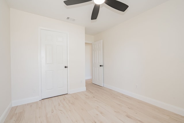 unfurnished bedroom with visible vents, baseboards, wood finished floors, and a ceiling fan