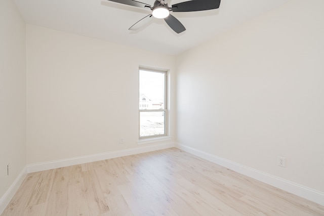 spare room featuring baseboards, light wood-type flooring, and ceiling fan