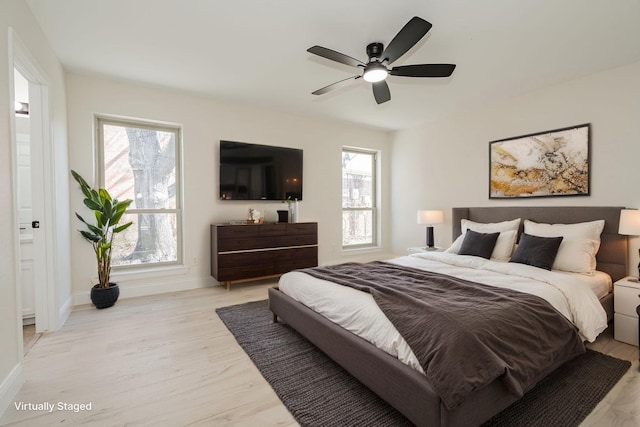 bedroom with baseboards, light wood-style floors, and a ceiling fan