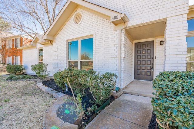 view of exterior entry with brick siding