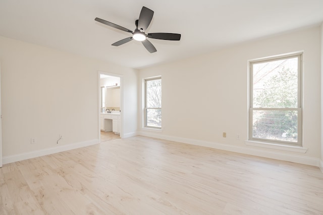 unfurnished room featuring a ceiling fan, baseboards, and light wood-type flooring