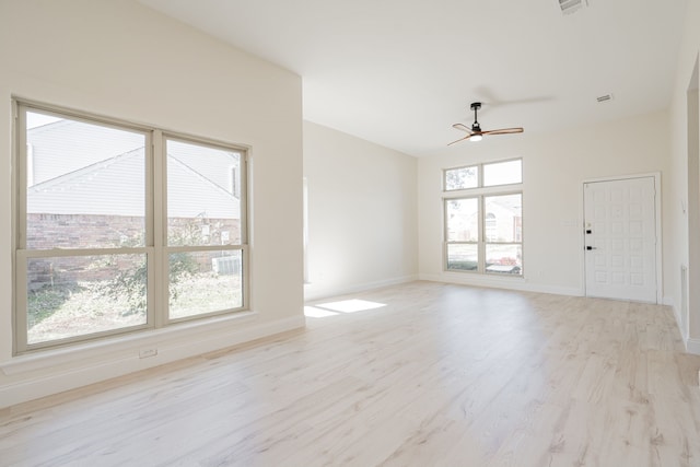 spare room with baseboards, ceiling fan, and light wood finished floors