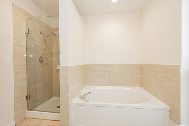 full bathroom featuring tile patterned floors, a stall shower, and a bath