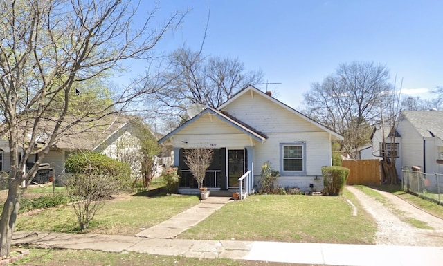 bungalow-style home featuring a front yard and fence