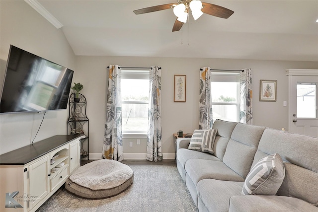 living area with lofted ceiling, wood finished floors, baseboards, and ceiling fan