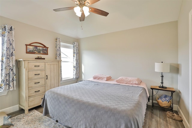 bedroom featuring ceiling fan, baseboards, and wood finished floors