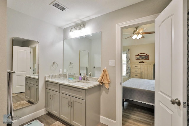 ensuite bathroom with visible vents, ensuite bathroom, a ceiling fan, wood finished floors, and vanity