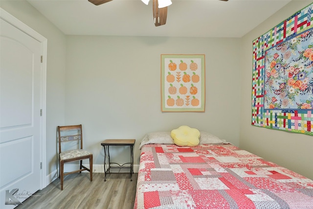 bedroom with ceiling fan, baseboards, and wood finished floors