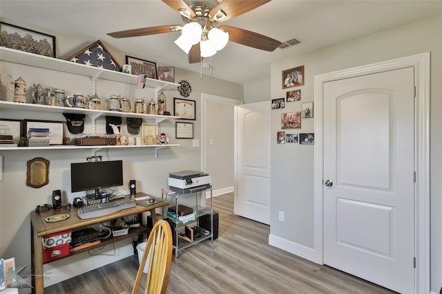 office with light wood-style flooring, baseboards, visible vents, and ceiling fan