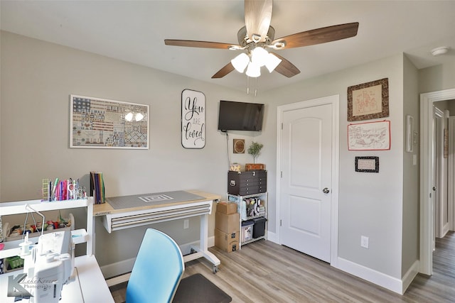 office area featuring baseboards, light wood-style floors, and ceiling fan